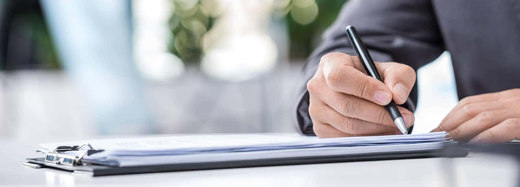 man signs papers in well lit room