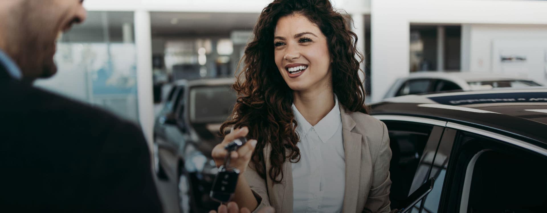Woman being handed new car keys for her new vehicle