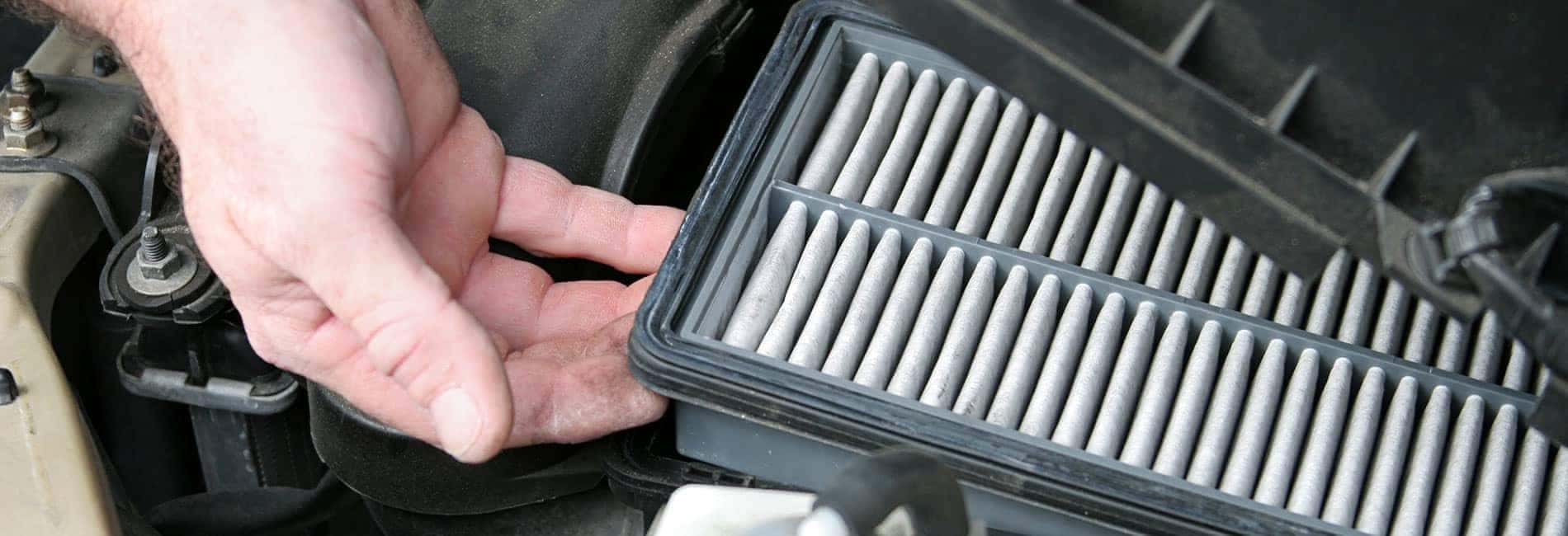 man's hand pulling out an air filter