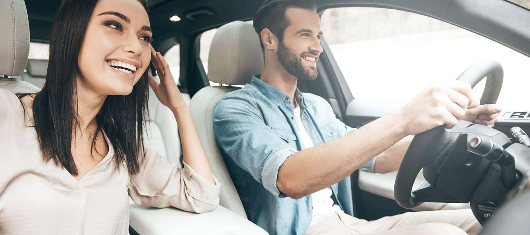 smiling couple in a car looking forward