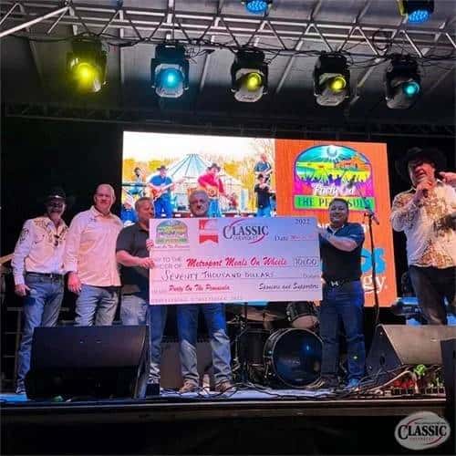 Group of people holding check on stage