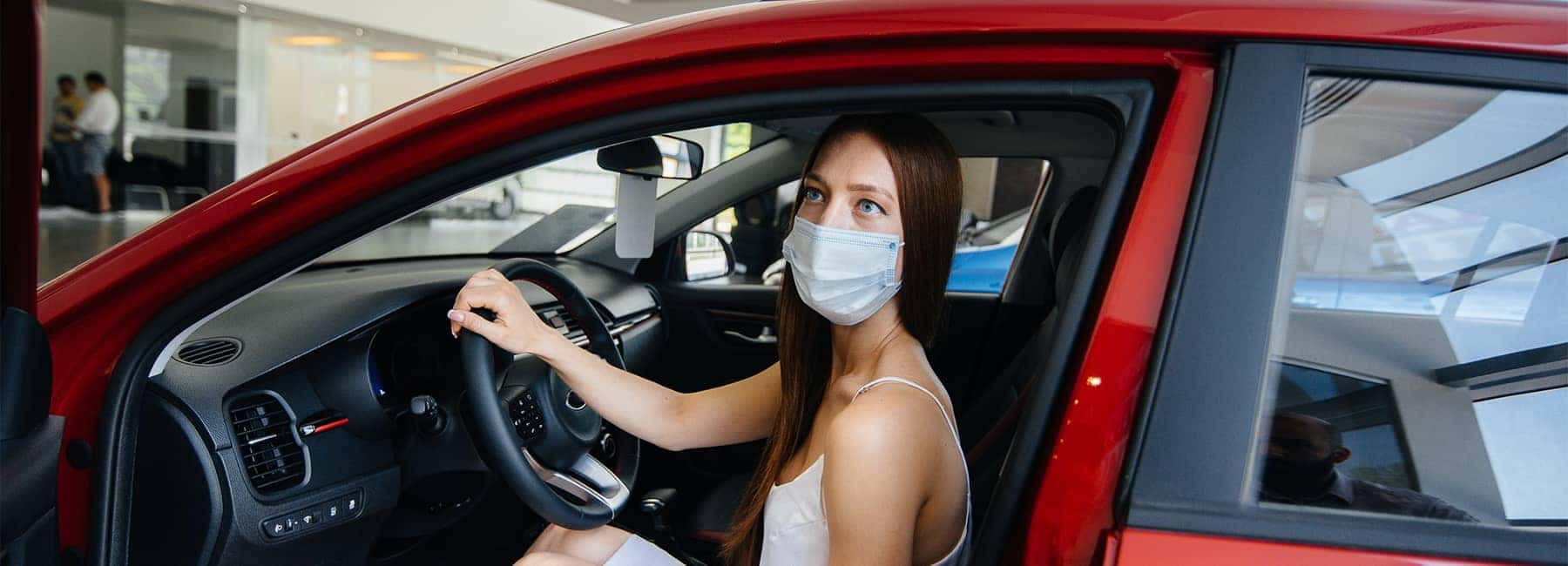 Female in a mask shopping for a new car