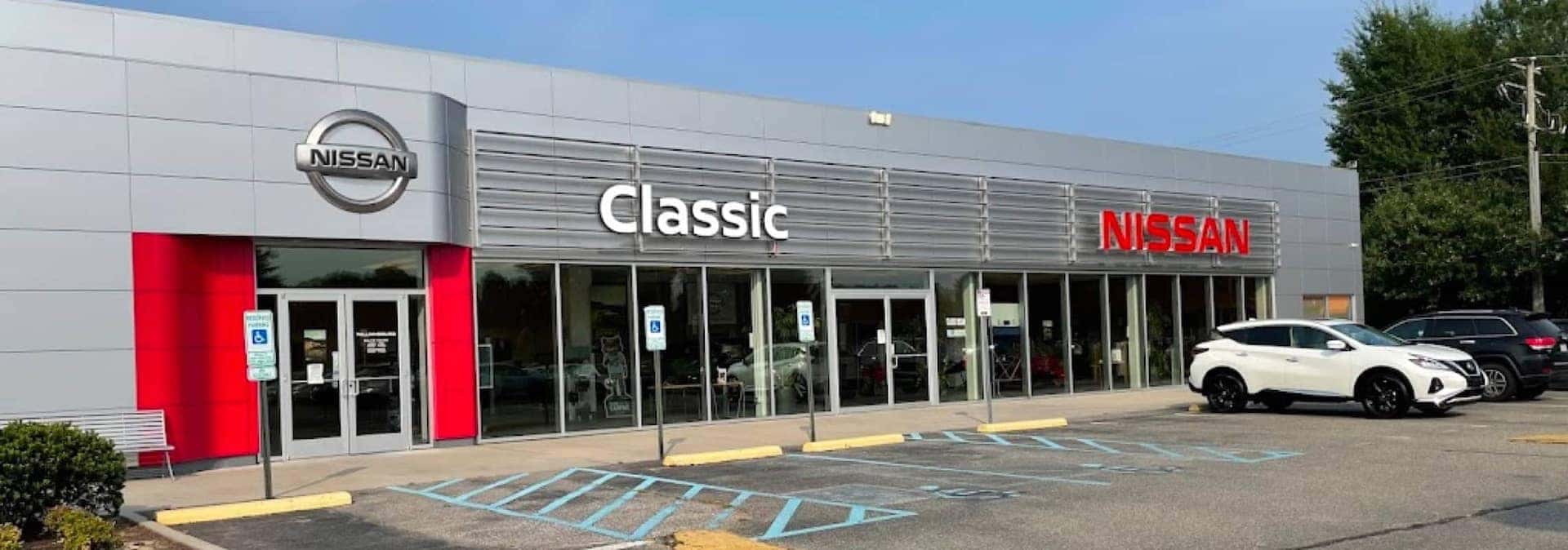 An exterior shot of a Nissan dealership at day