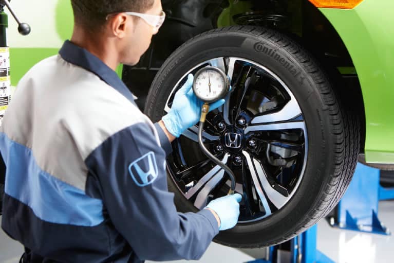 Honda-Technician-Checking-Tire-Pressure