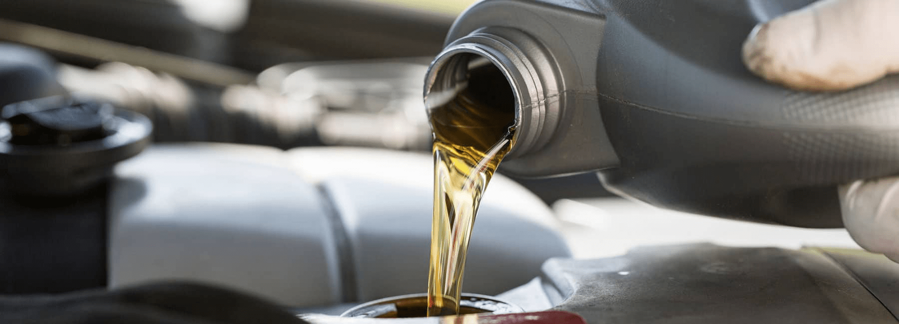 service technician pours oil in car engine