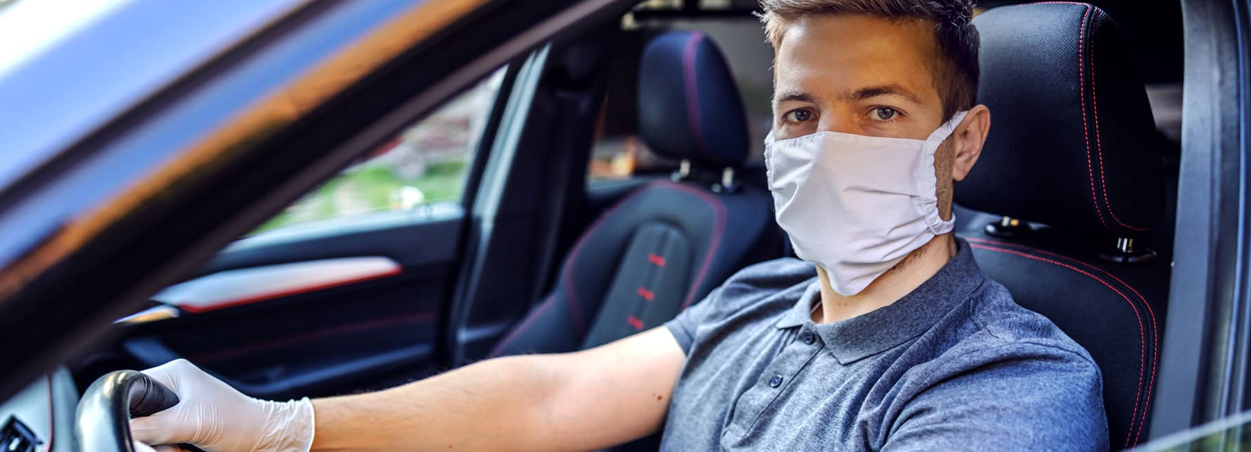 man wearing mask in drivers seat