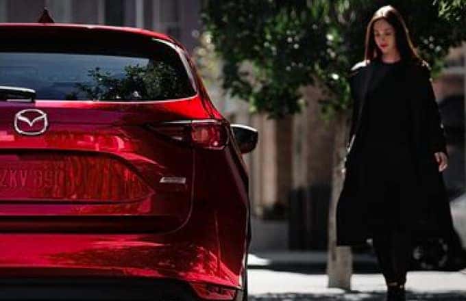 Red Mazda and woman on the left