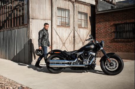 man approaching harley parked outside warehouse