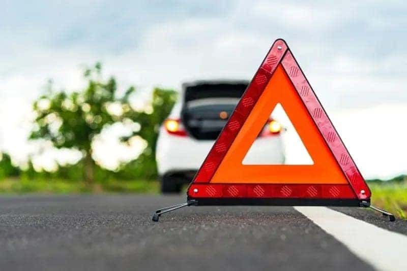 Close-up of a traffic cone in front of a parked car