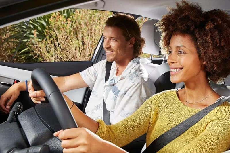 Woman driving a car with man in the passenger seat