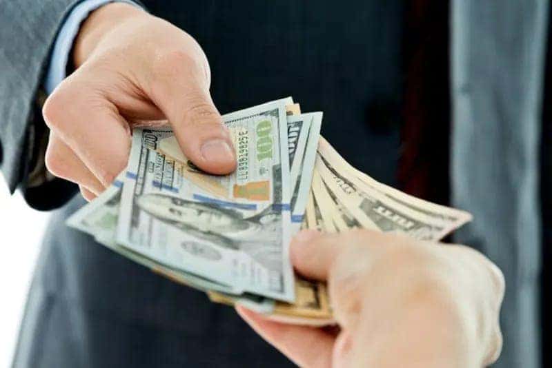 Man handing dollar bills over to customer