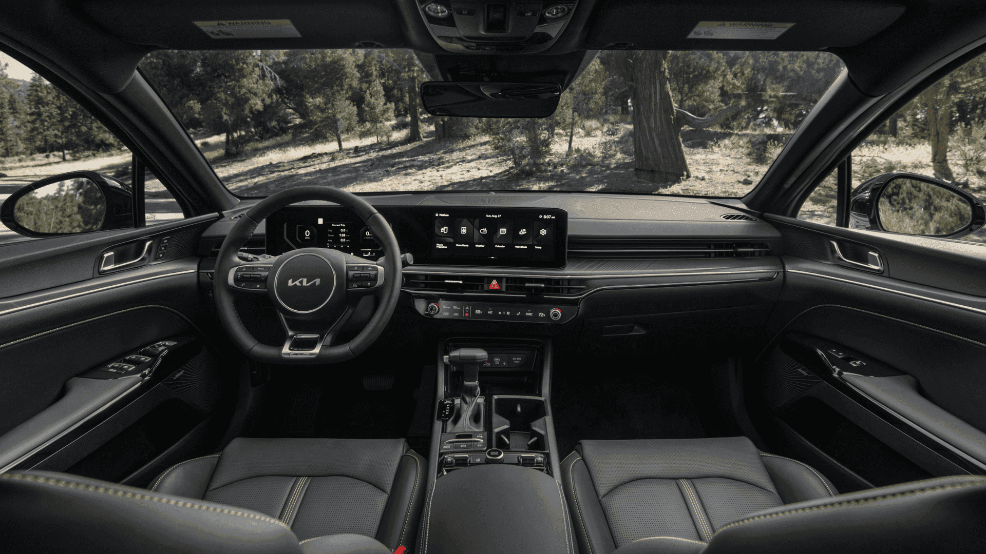 2025 Kia K5 interior featuring a digital driver display and infotainment touchscreen, paired with a sleek dashboard and premium materials.
