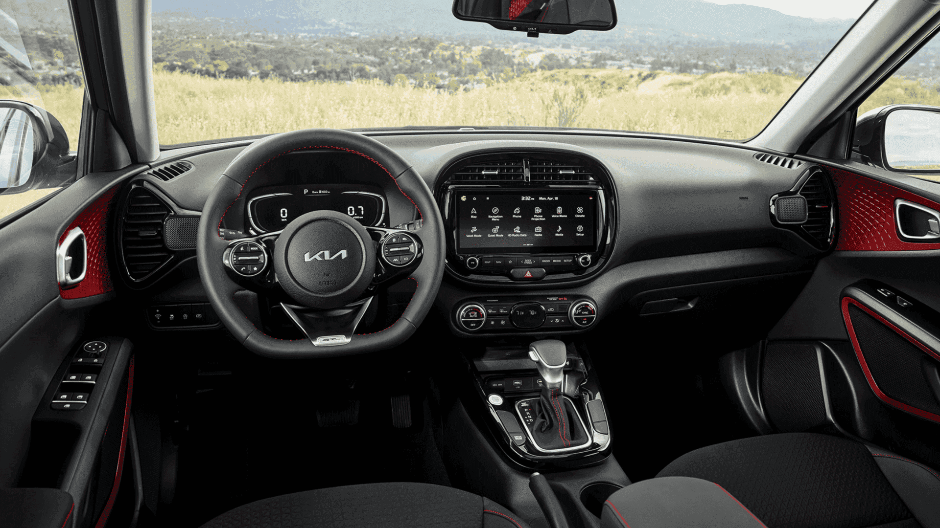 Driver-focused cockpit of the 2025 Kia Soul featuring a modern infotainment touchscreen, digital gauge cluster, and sporty red-accented interior.