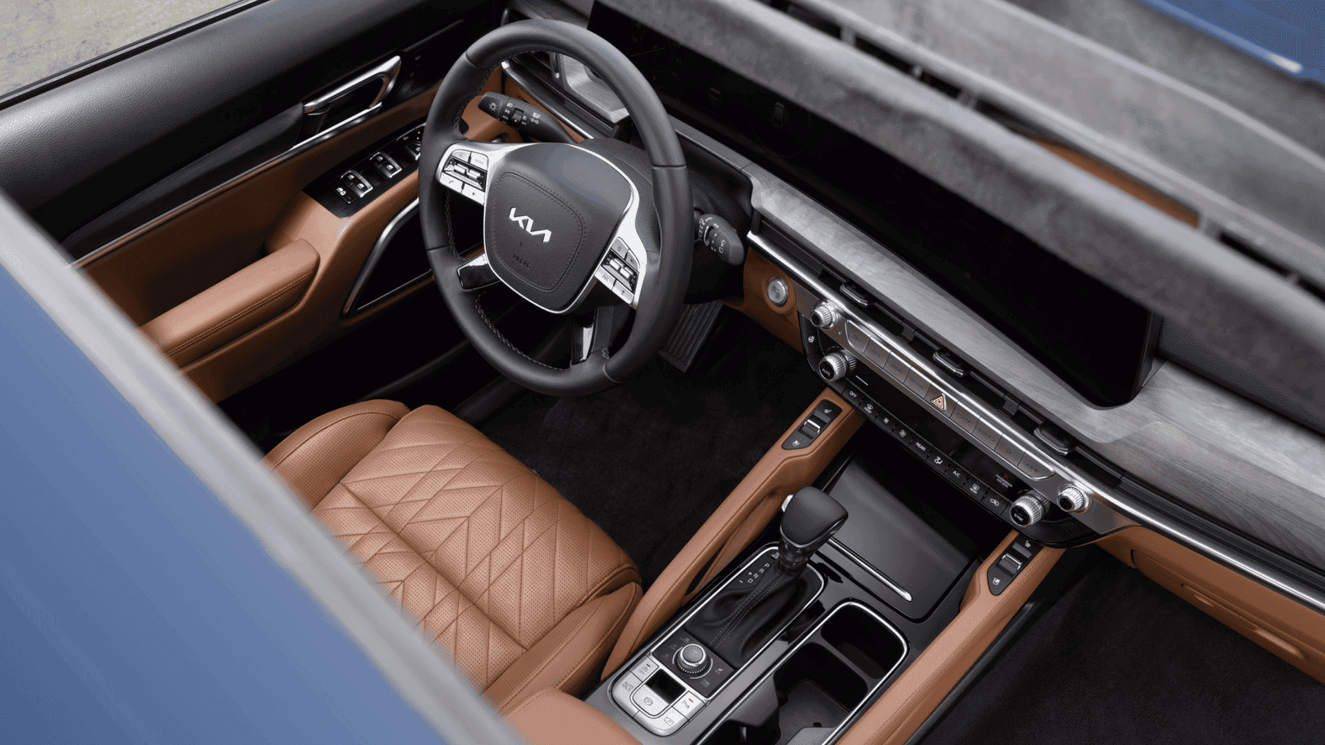 2025 Kia Telluride interior view from sunroof, showcasing premium brown leather seats, ergonomic controls, and advanced dashboard design.