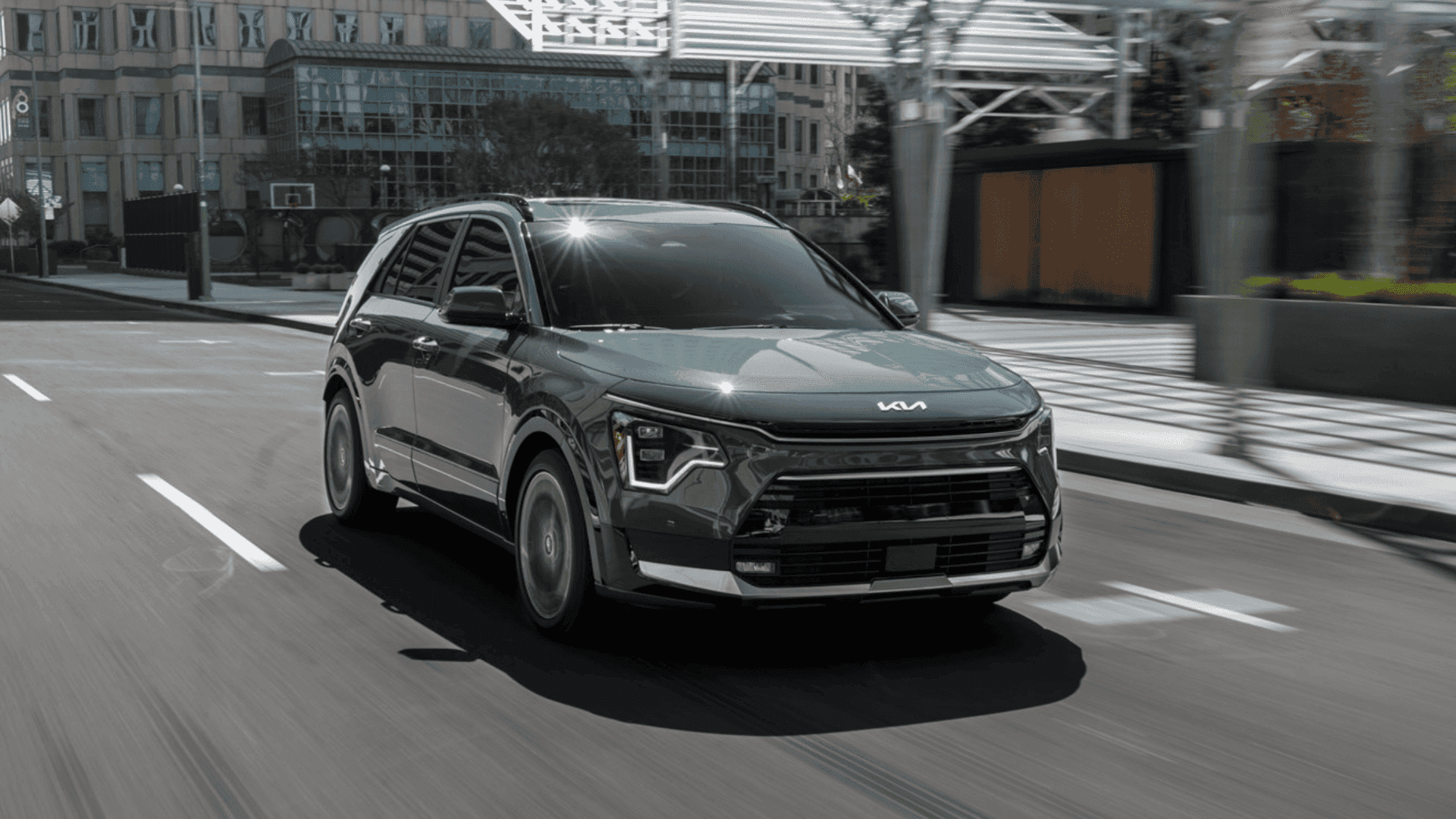 2025 Kia Niro compact crossover driving through the city, combining sleek design with eco-friendly efficiency.