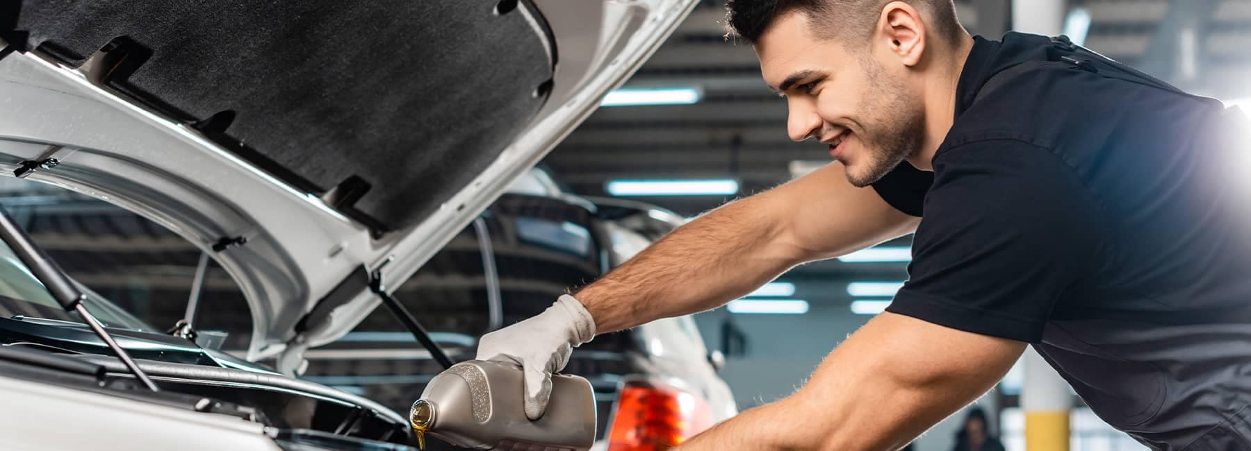 Mechanic replacing engine oil in a vehicle