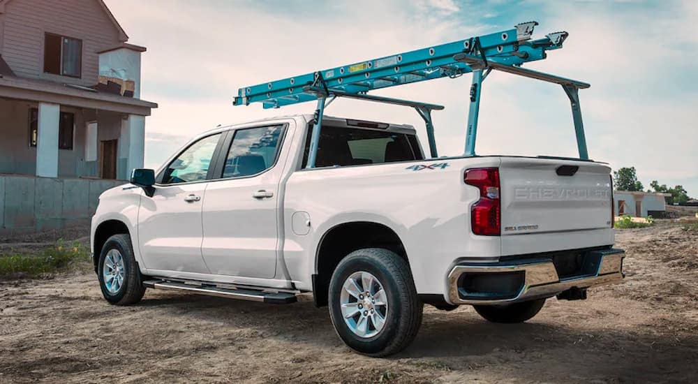 A white 2021 Chevy Silverado 1500 is shown with a ladder rack and blue ladder.