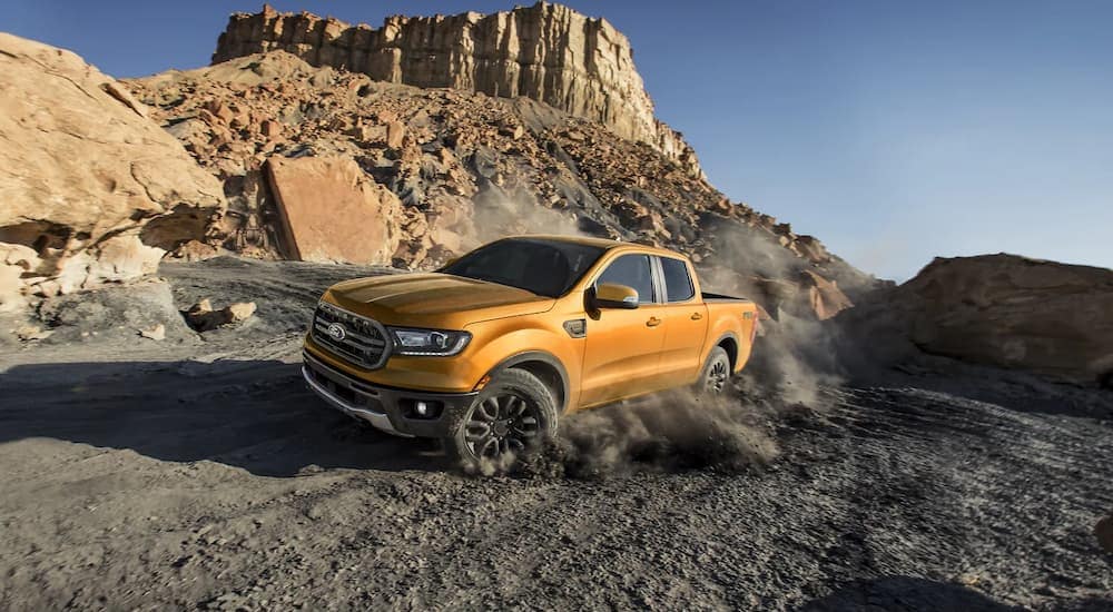 A gold 2021 Ford Ranger FX4 is shown off-roading in a desert area.