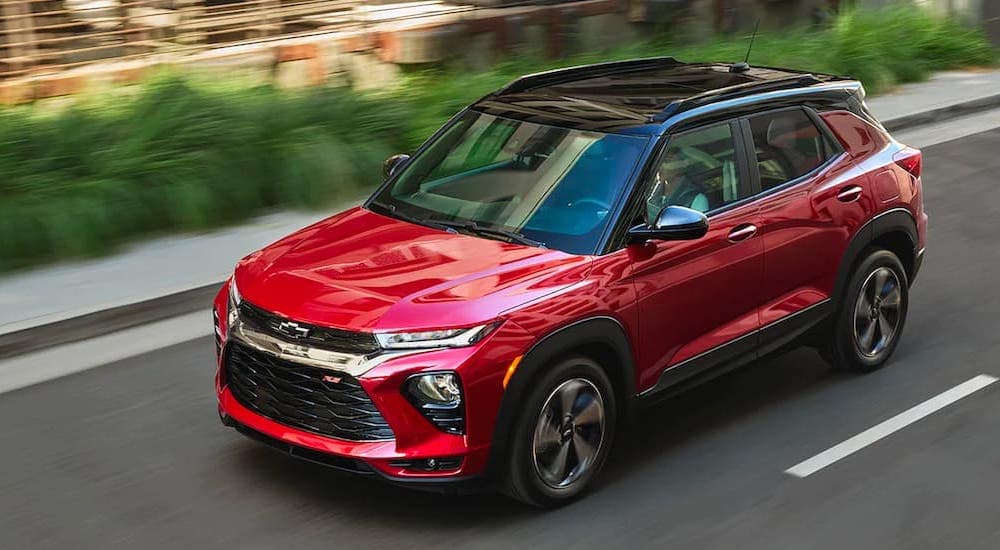 A red 2021 Chevy Trailblazer is driving past blurred shrubs after leaving a Tupelo GM dealer.