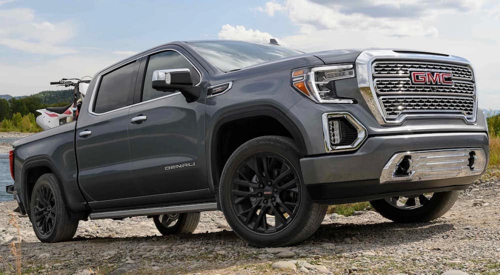 A silver 2021 GMC Sierra 1500 Denali is shown parked on with an ATV in the bed.