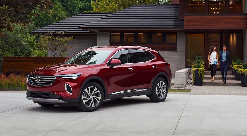 A red 2021 Buick Envision is shown parked in the driveway of a modern home.