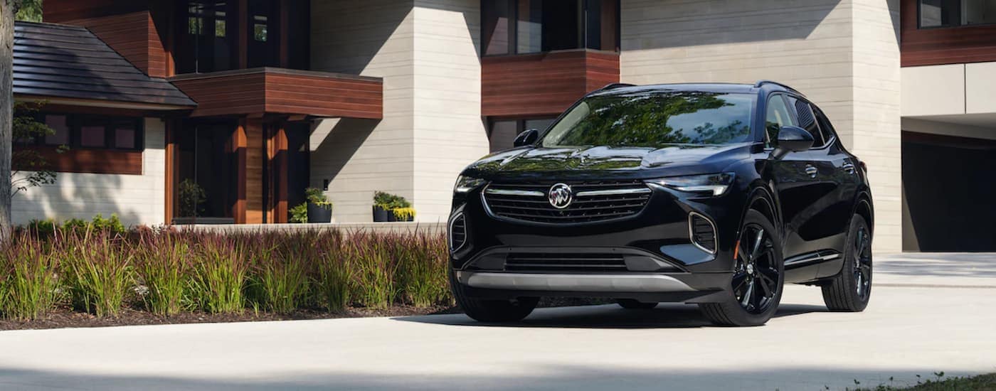 A black 2021 Buick Envision is shown from the front parked in a modern driveway. 