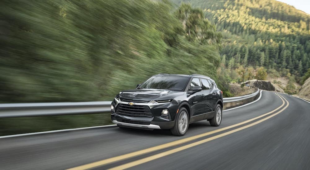 A grey 2021 Chevy Blazer is shown from the front driving on an open road after looking at Chevy SUVs.