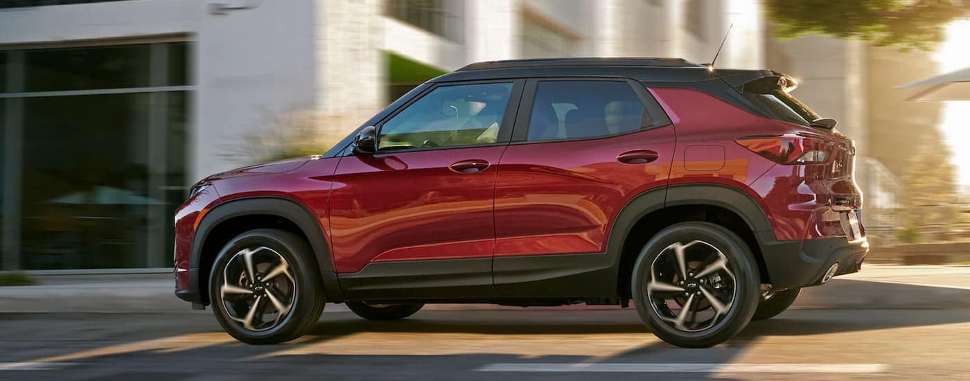 A red 2021 Chevy Trailblazer is shown from the side driving through a city.