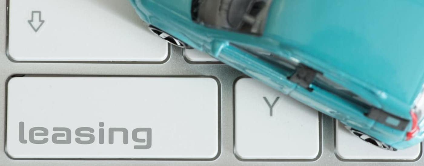 A keyboard shows a leasing button and a toy car.