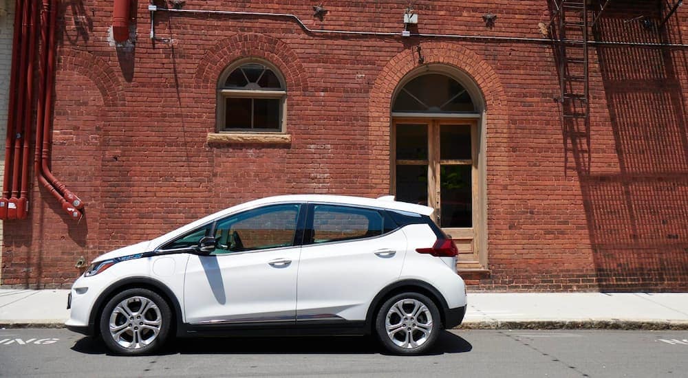 A white 2020 Chevy Bolt EV is shown outside a brick building after the owner found out how to sell your car.