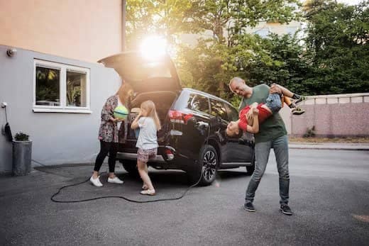 Family having fun outside of car while vehicle is charging