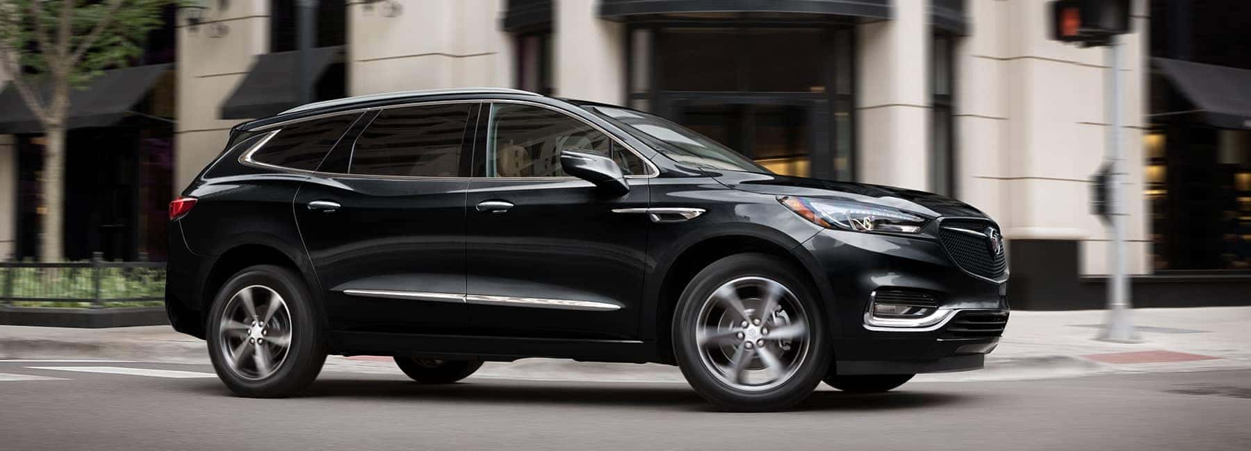 Black 2020 Buick Enclave drives through intersection