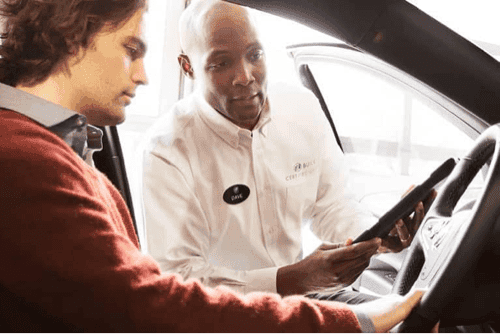 Service technician advises customer in his car