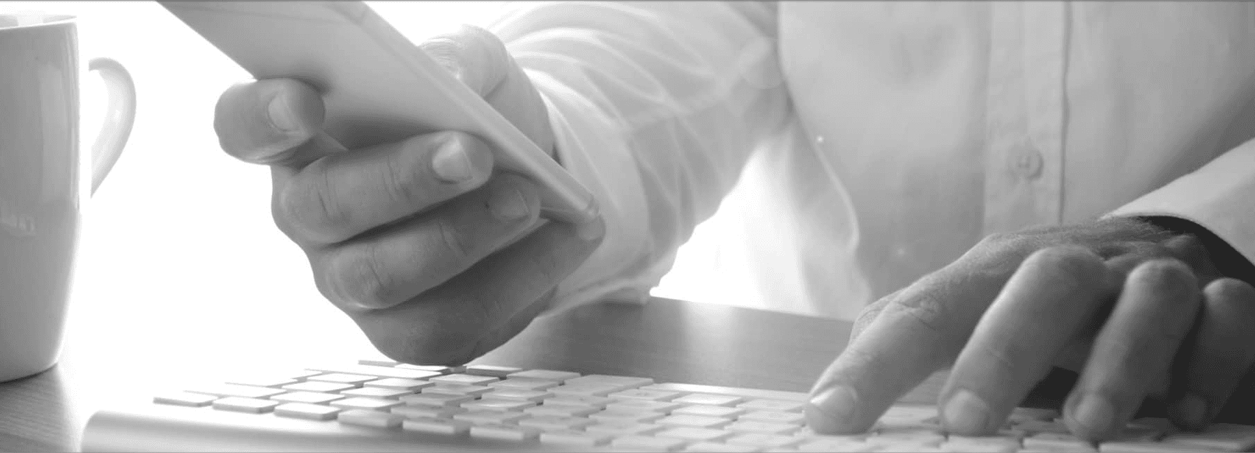 man typing on keyboard with coffee