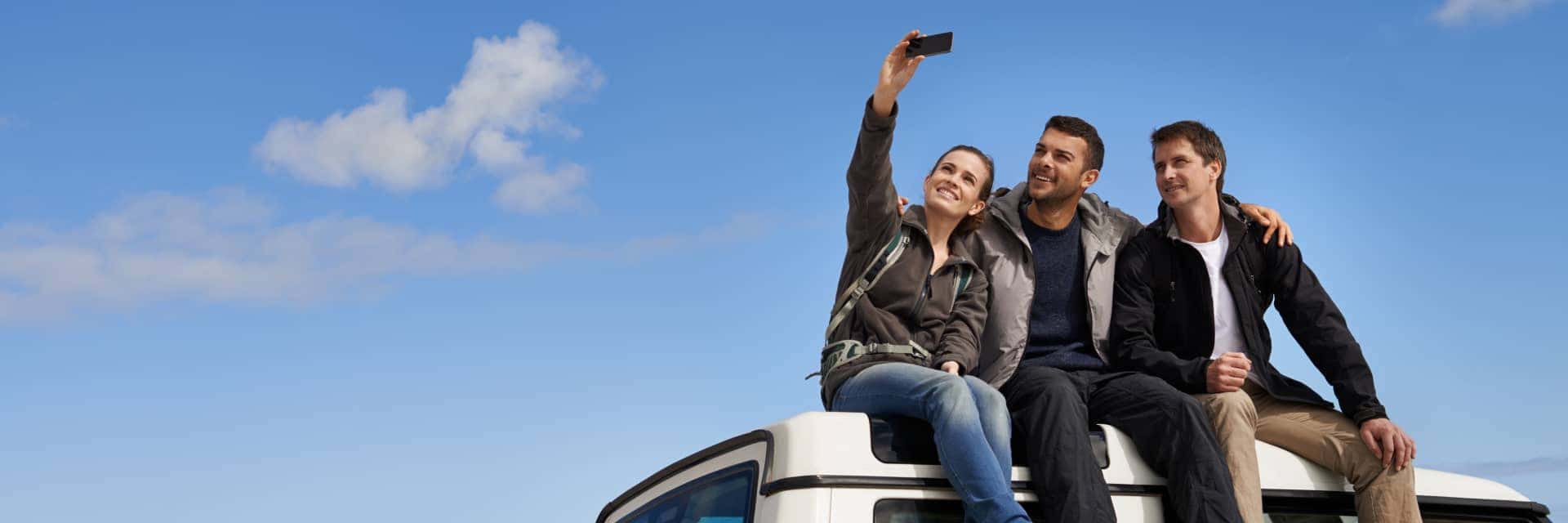 group of people taking a selfie on a vehicle