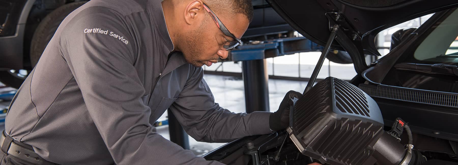 GM certified technician working on car engine