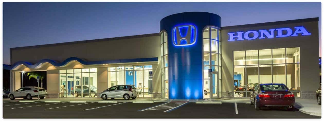 An exterior shot of a Honda dealership at night.