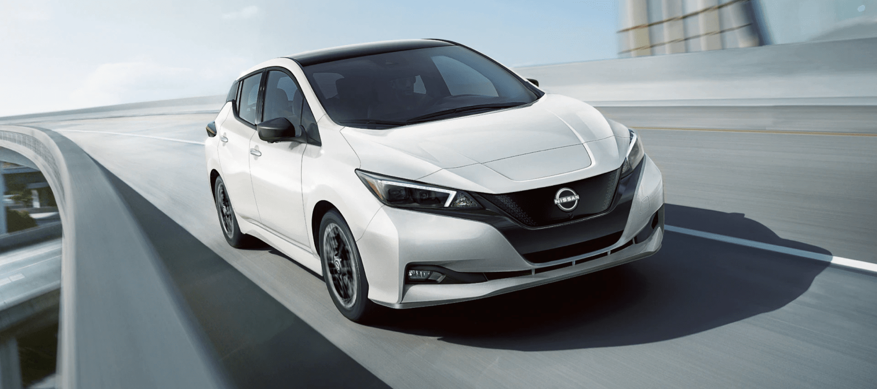 white-Nissan-Leaf-drives-on-modern-highway