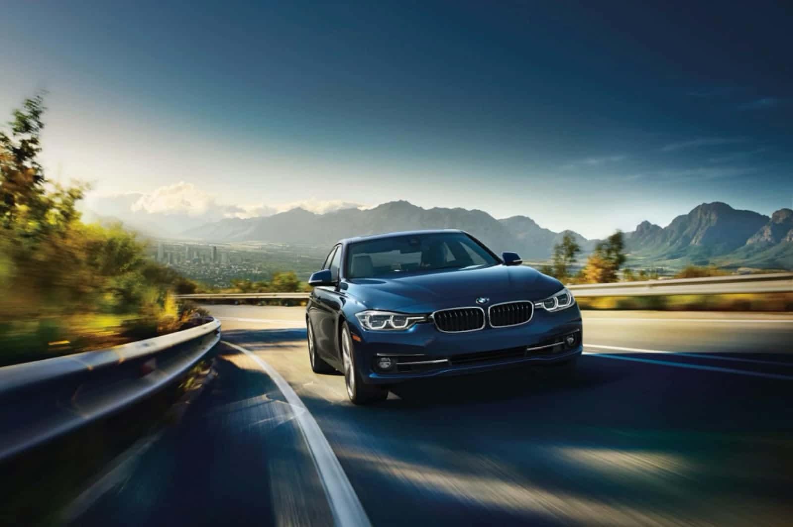 BMW 3 Series driving with mountainous background