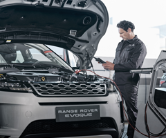 A Land Rover service technician working on a new Range Rover Evoque SUV.