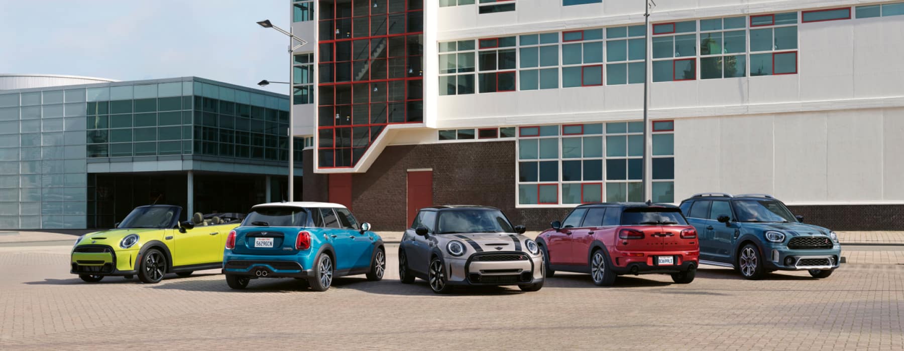 Family of MINI’s parked in front of a building.