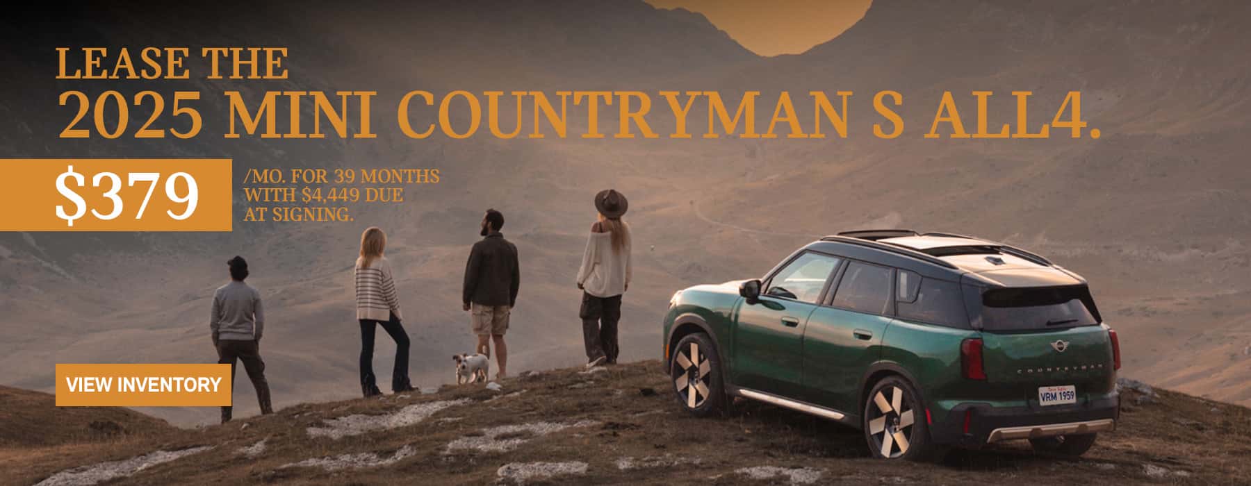 2 men, 2 woman and dog next to a green MINI Countryman overlooking a mountaintop.