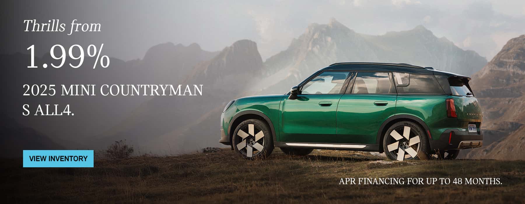 Side view of green MINI Countryman S ALL4 parked on a grass field with a mountain in the background.
