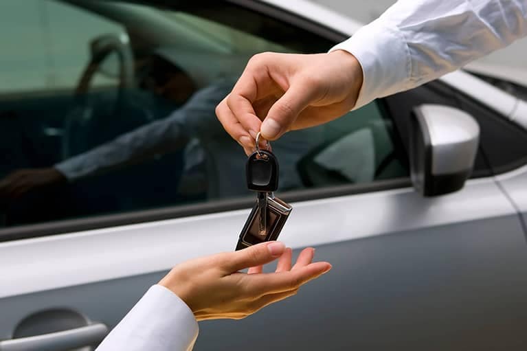Person Handing Over Car Keys