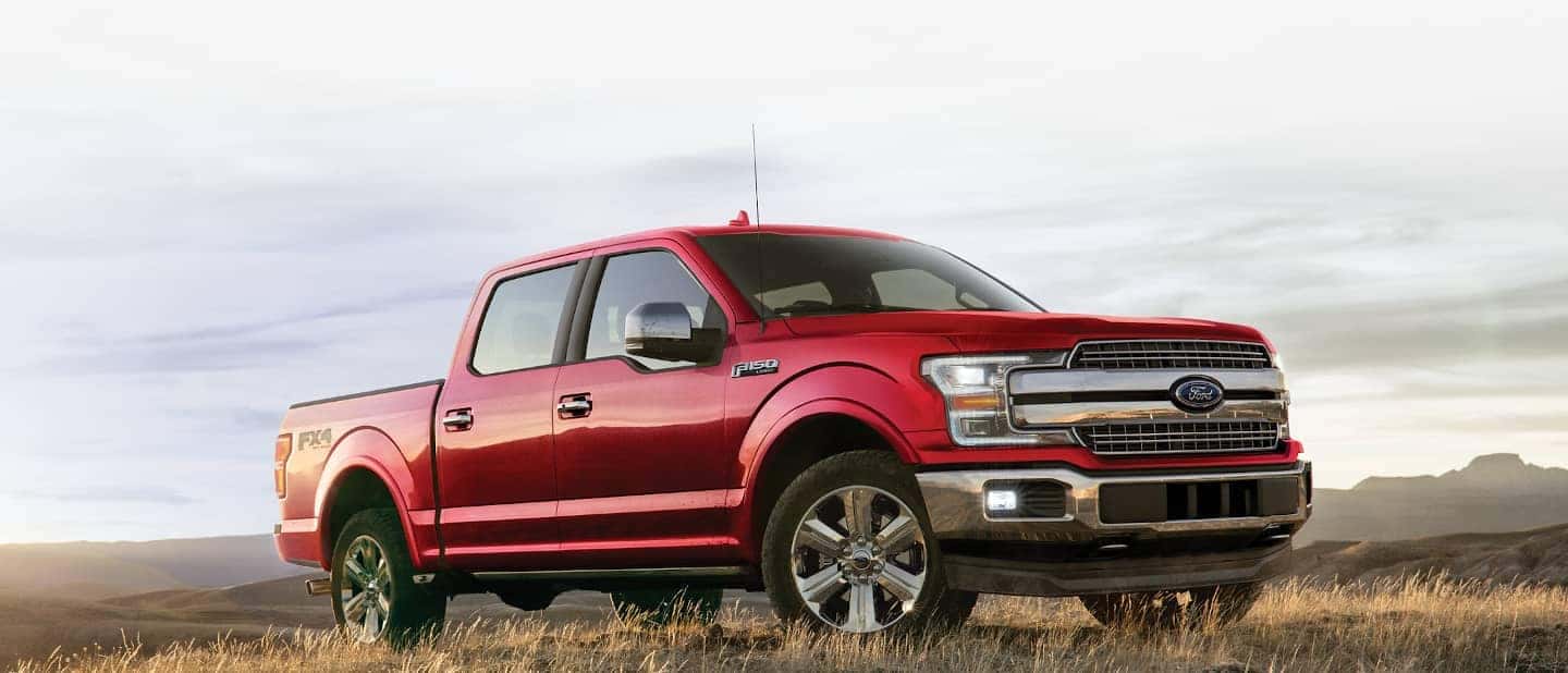 red Ford Lariat parked in yellow grass