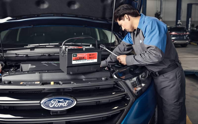 Service Tech is changing battery on a Ford vehicle.