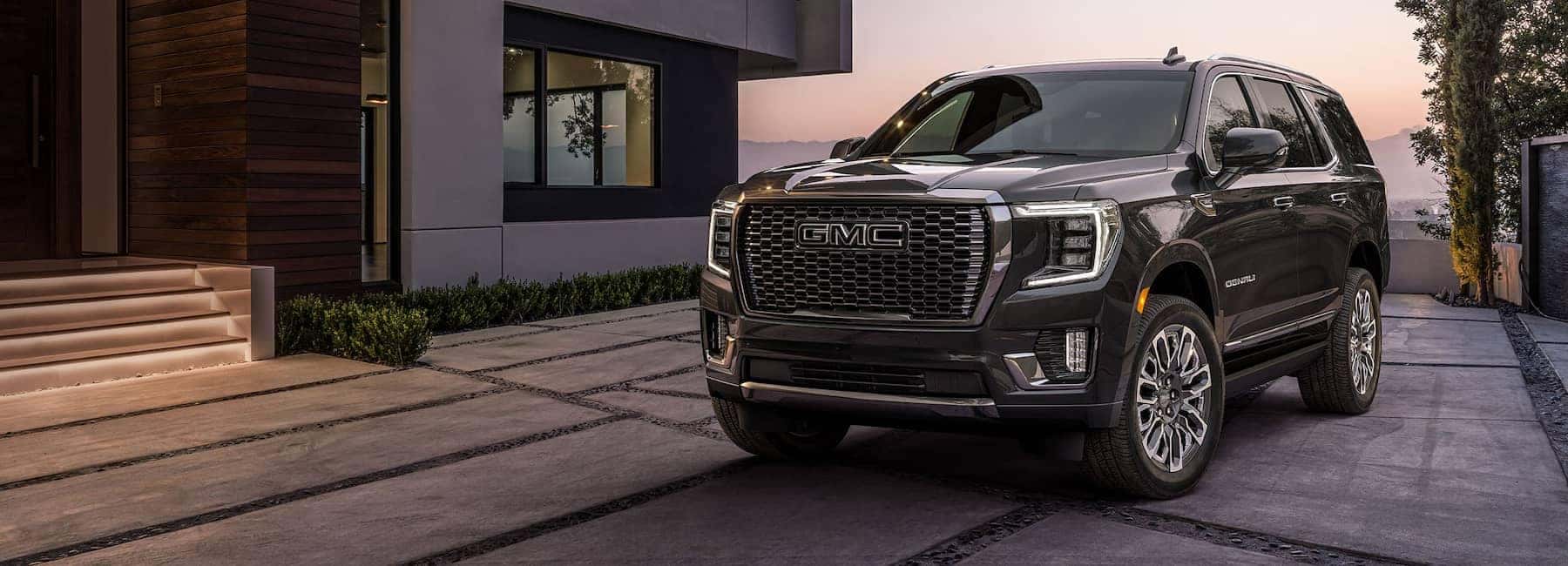 2023 GMC Yukon parked outside of modern house