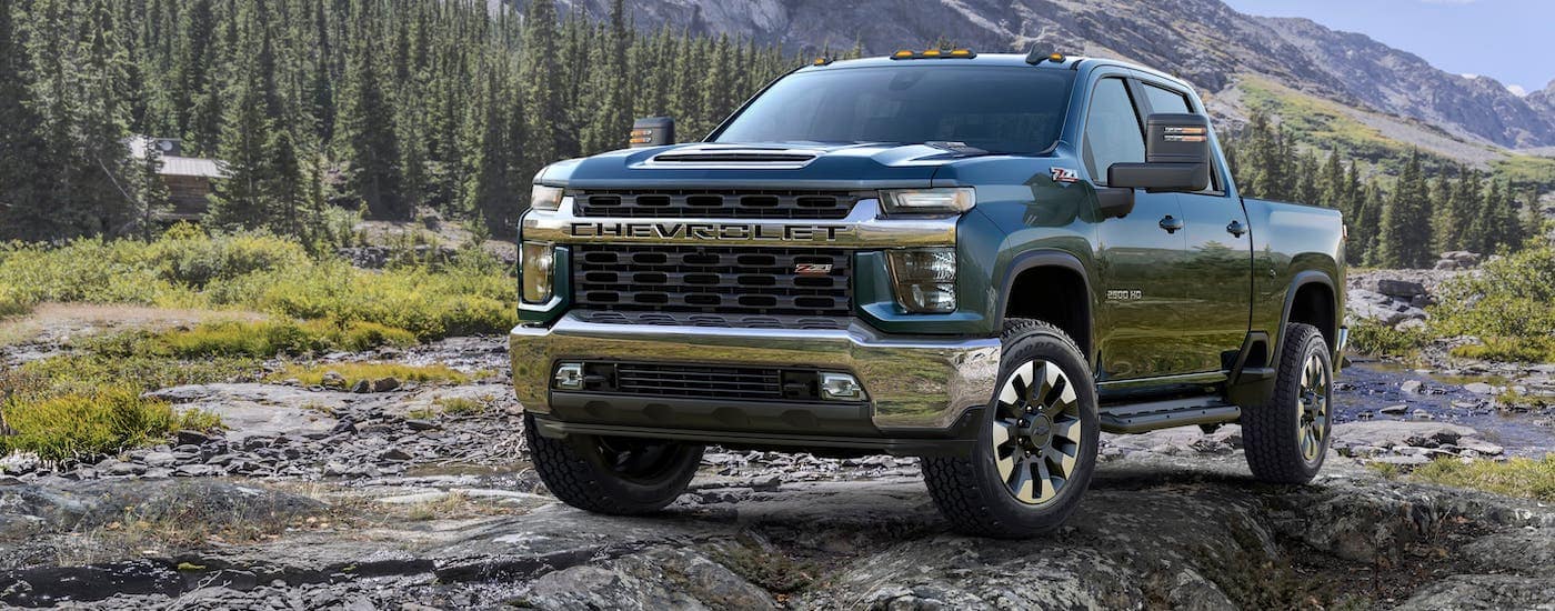 A blue 2020 Chevy Silverado 2500HD Z71 is parked on rocks in front of mountains.
