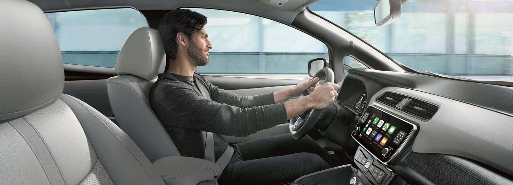 Young man driving a 2020 Nissan Leaf