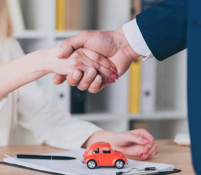 handshake over car signing